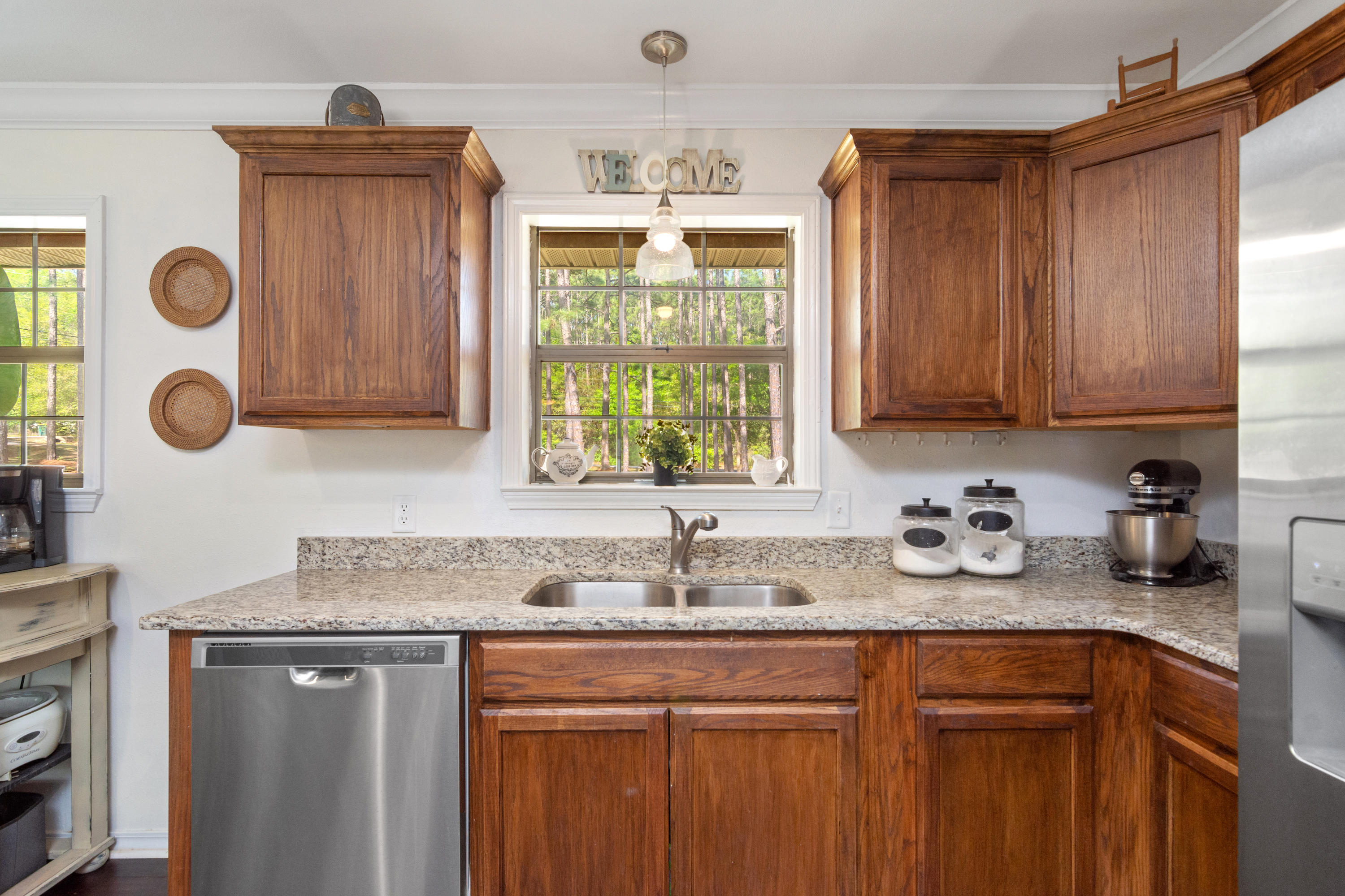 658 Ridge Lake Road Crestview, FL 32536 - Photo 11 of 47 a kitchen with stainless steel appliances granite countertop a sink a window and cabinets