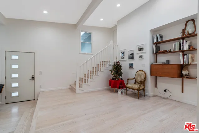 a kitchen with white cabinets and window