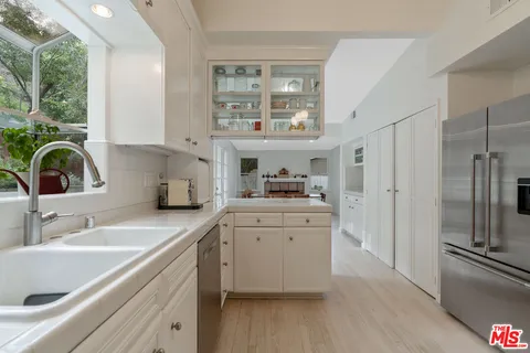 a kitchen with granite countertop white cabinets and white appliances