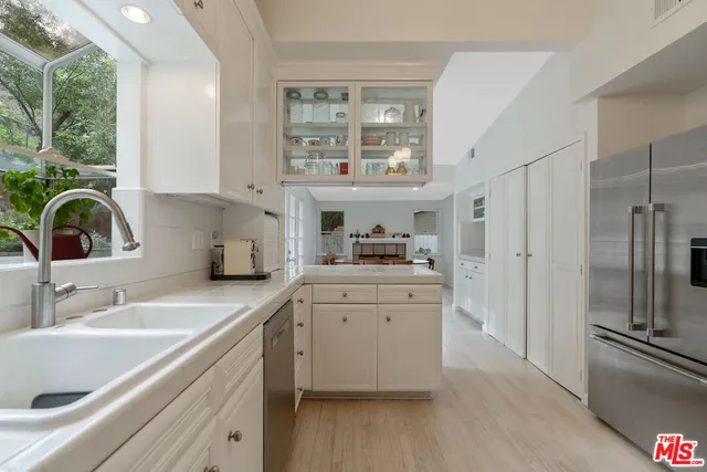 a kitchen with granite countertop white cabinets and white appliances