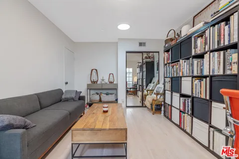 a bed sitting in a spacious bedroom next to a window