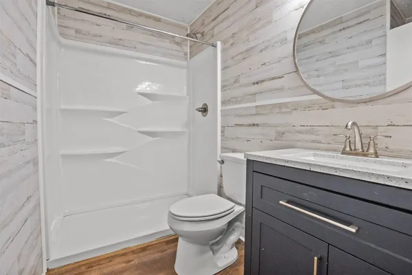 a bathroom with a granite countertop toilet sink and shower