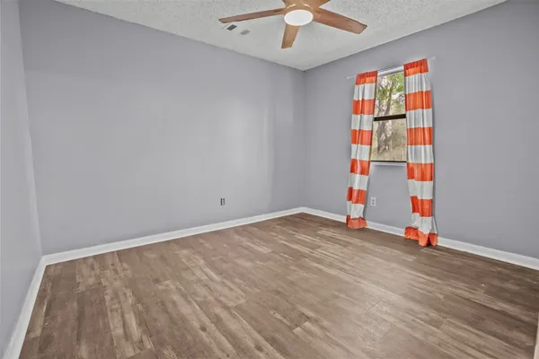 an empty room with wooden floor and entryway