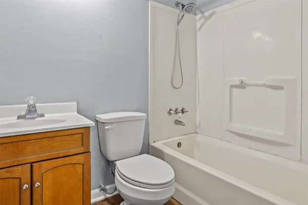 a white toilet sitting next to a bath tub