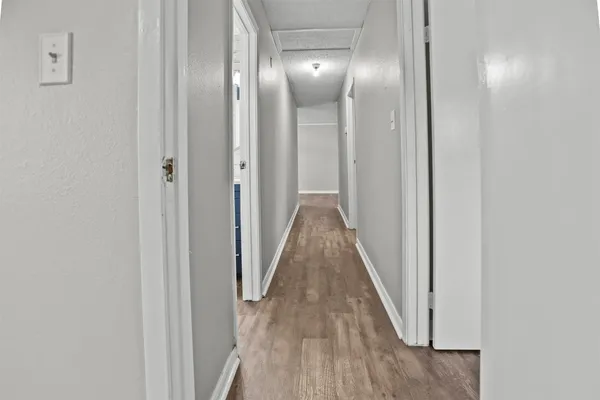 a view of a hallway with wooden floor