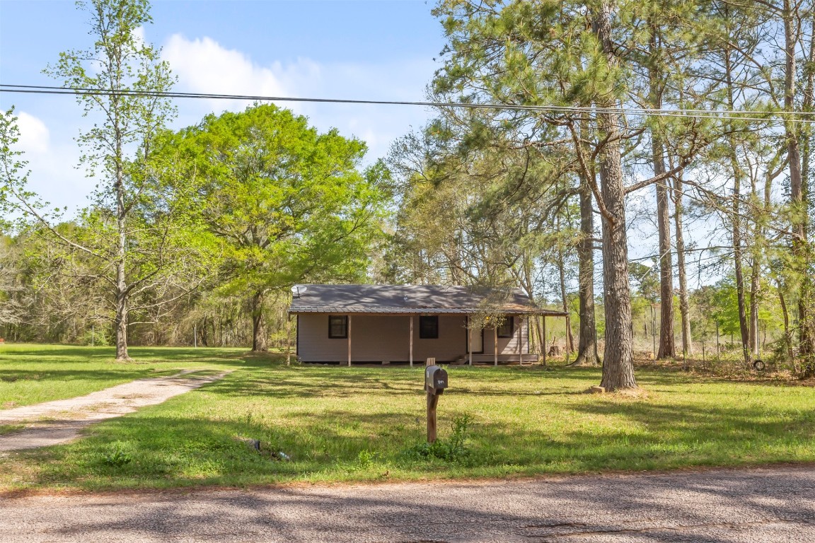 801 Campbell Acres Road Cleveland, TX 77328 - Photo 21 of 36 a front view of a house with a garden and trees