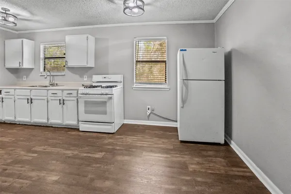a kitchen with a refrigerator sink stove and cabinets