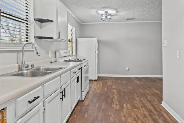 a kitchen with a sink stove and cabinets