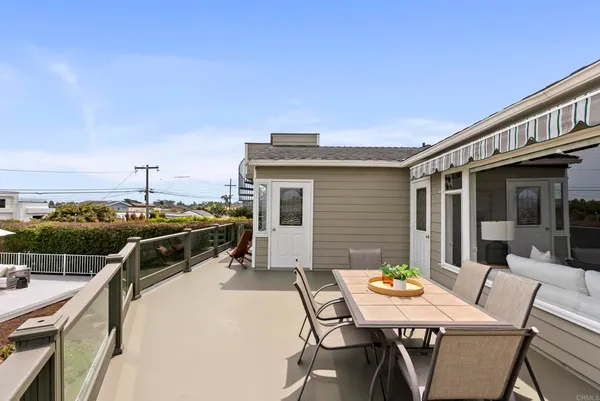 a view of a patio with table and chairs with wooden floor and fence