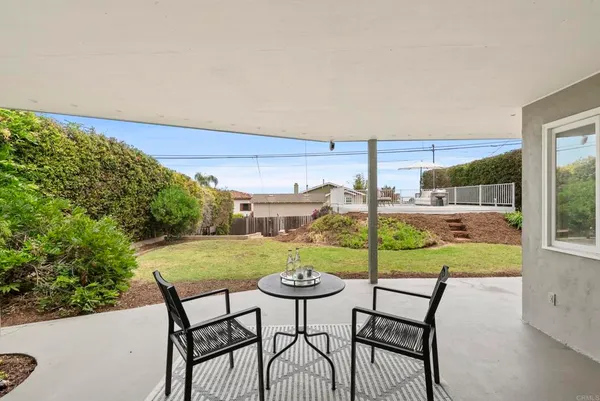 a view of a chairs and table in patio with a yard