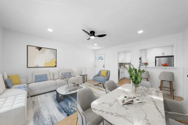 a living room with furniture kitchen view and a chandelier