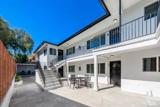 a view of a patio with table and chairs with wooden fence and plants