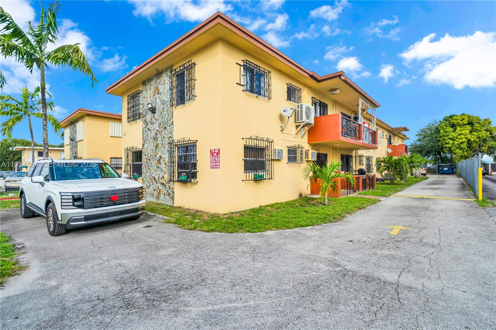 47 Northwest 47th Avenue, Unit 1 Miami, FL 33126 - Photo 2 of 14 a view of a white house with a yard and table and chairs under an umbrella