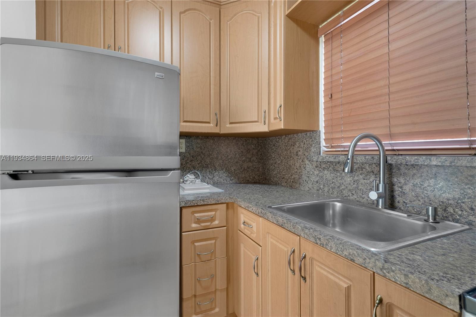 47 Northwest 47th Avenue, Unit 1 Miami, FL 33126 - Photo 8 of 14 a kitchen with granite countertop a sink and a granite top