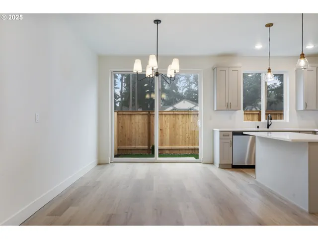a view of a room with wooden floor and large window