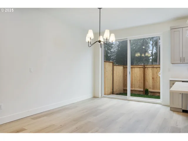 a view of a room with a chandelier fan and windows