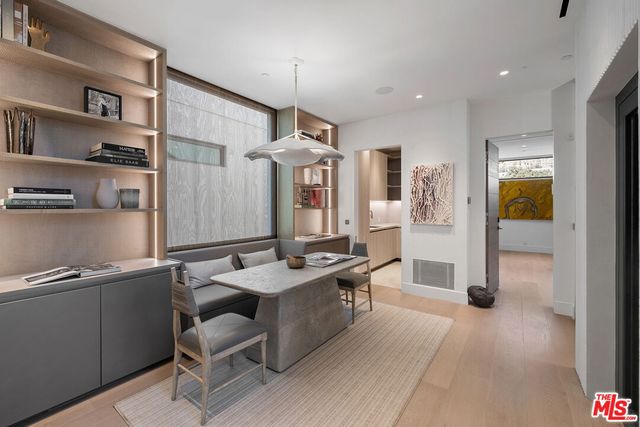 a kitchen with stainless steel appliances kitchen island granite countertop a refrigerator a stove and a sink with wooden floor