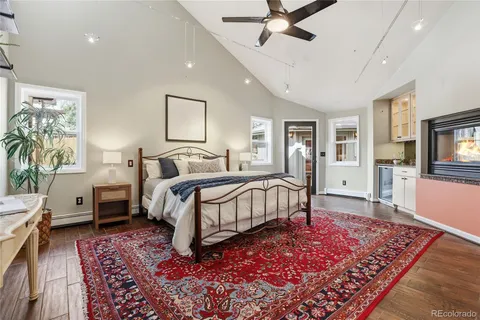 a spacious bedroom with a bed and a flat screen tv
