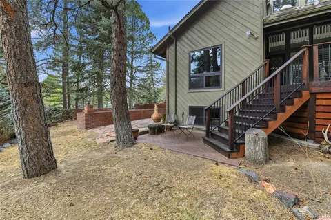 a view of a house with backyard and trees