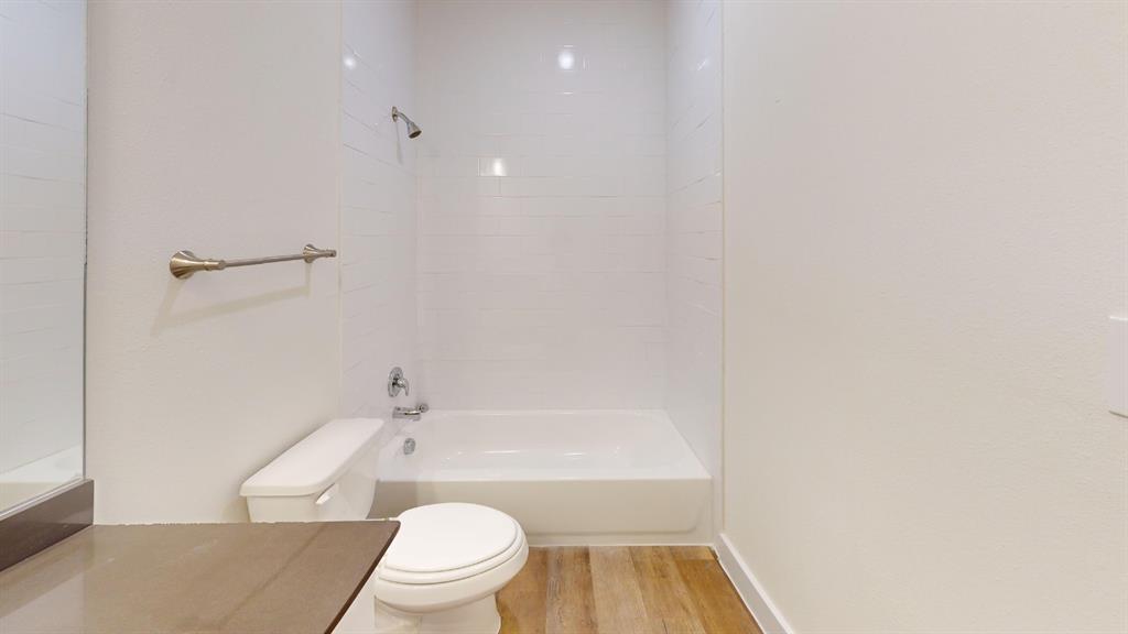 373 Buck Ridge Drive Frisco, TX 75068 - Photo 22 of 24 Bathroom featuring a shower/tub combination, wall-mounted showerhead, and wood-finish flooring