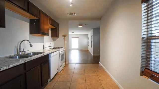 a kitchen with stainless steel appliances granite countertop a sink and dishwasher a stove top oven with wooden floor