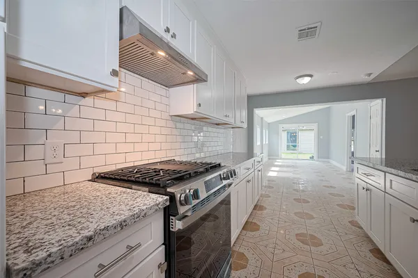 a kitchen with granite countertop a stove and a sink