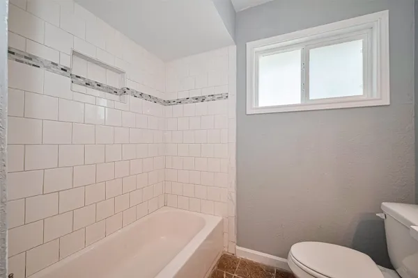 a white bath tub sitting next to a toilet