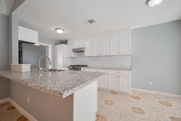 a kitchen with granite countertop a sink and cabinets
