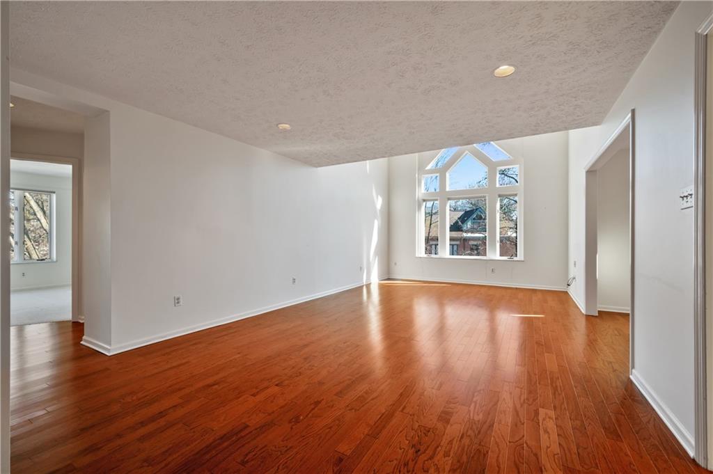 100 Denniston Street, Unit 304 Pittsburgh, PA 15206 - Photo 2 of 27 a view of an empty room with wooden floor and a window