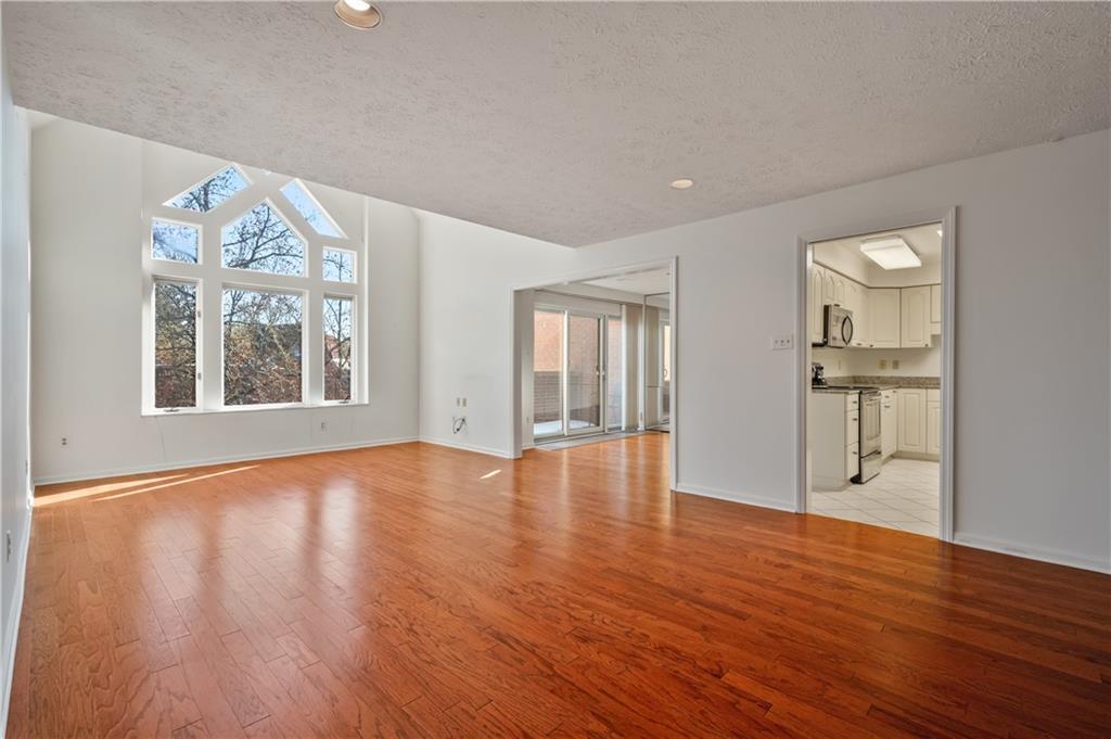 100 Denniston Street, Unit 304 Pittsburgh, PA 15206 - Photo 3 of 27 an empty room with wooden floor and windows