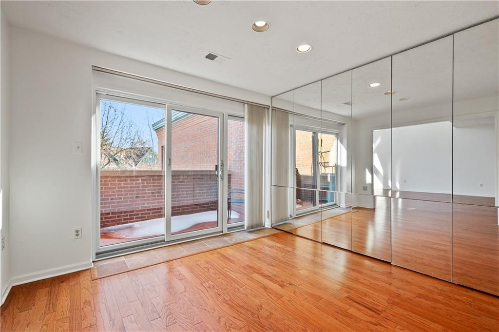 100 Denniston Street, Unit 304 Pittsburgh, PA 15206 - Photo 8 of 27 a view of an empty room with wooden floor and a window