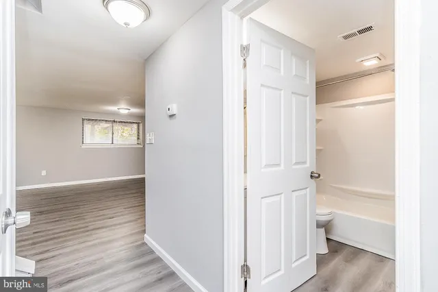 a view of bathroom with bathtub wooden floor and window