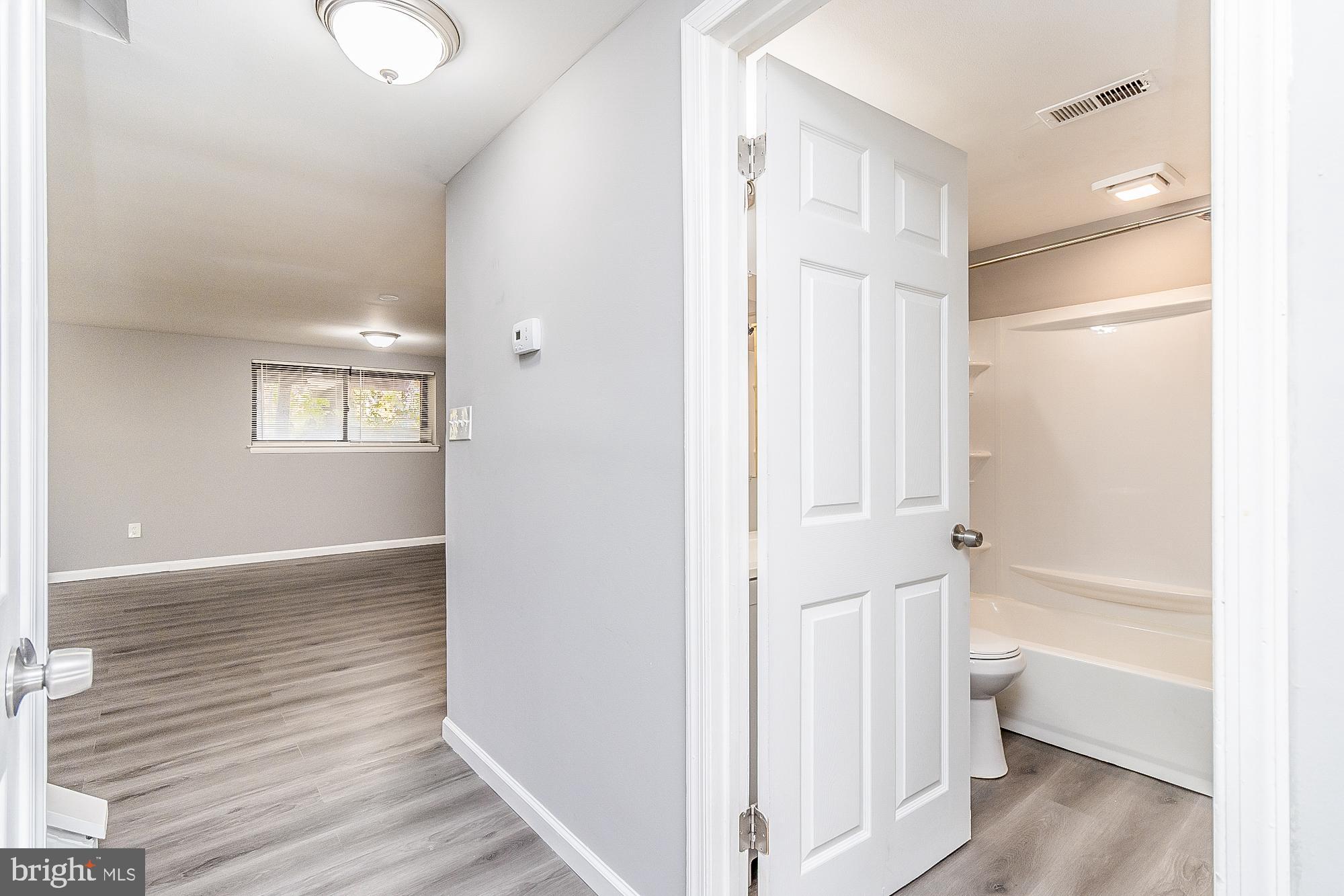 4006 Pinewood Avenue, Unit 1 Baltimore, MD 21206 - Photo 13 of 25 a view of bathroom with bathtub wooden floor and window