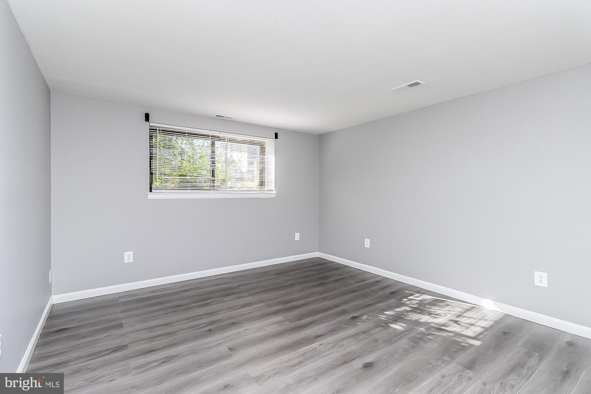 4006 Pinewood Avenue, Unit 1 Baltimore, MD 21206 - Photo 17 of 25 a view of an empty room with wooden floor and a window