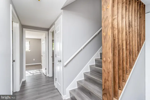 a view of staircase with wooden floor and white walls