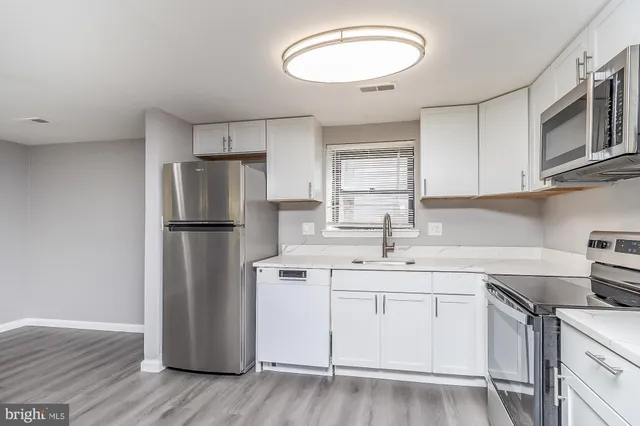 a kitchen with a sink stainless steel appliances and cabinets