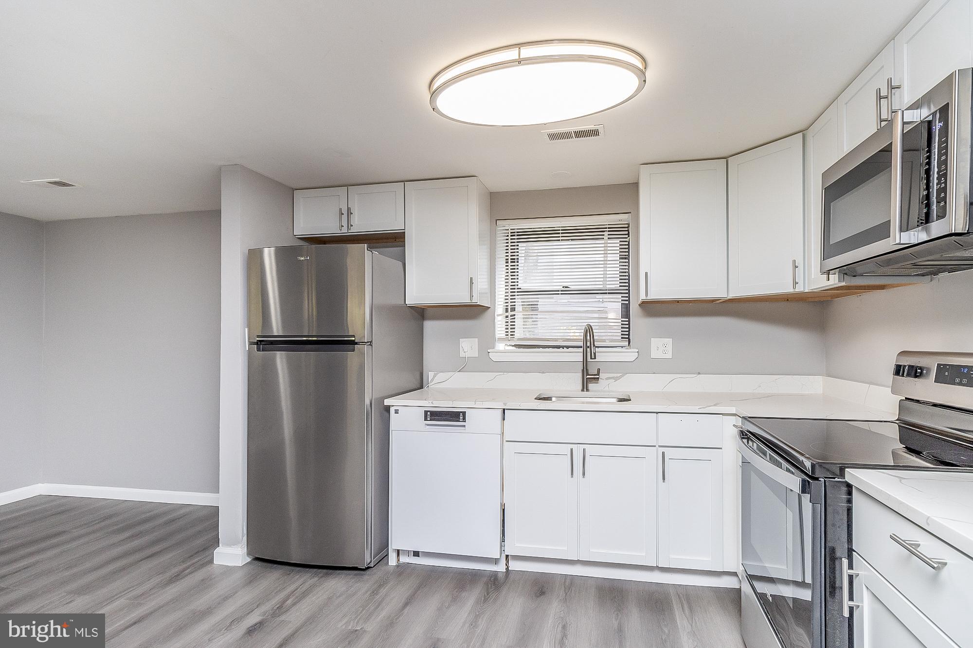 4006 Pinewood Avenue, Unit 1 Baltimore, MD 21206 - Photo 4 of 25 a kitchen with a sink stainless steel appliances and cabinets