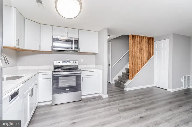 a kitchen with granite countertop a stove top oven and cabinets