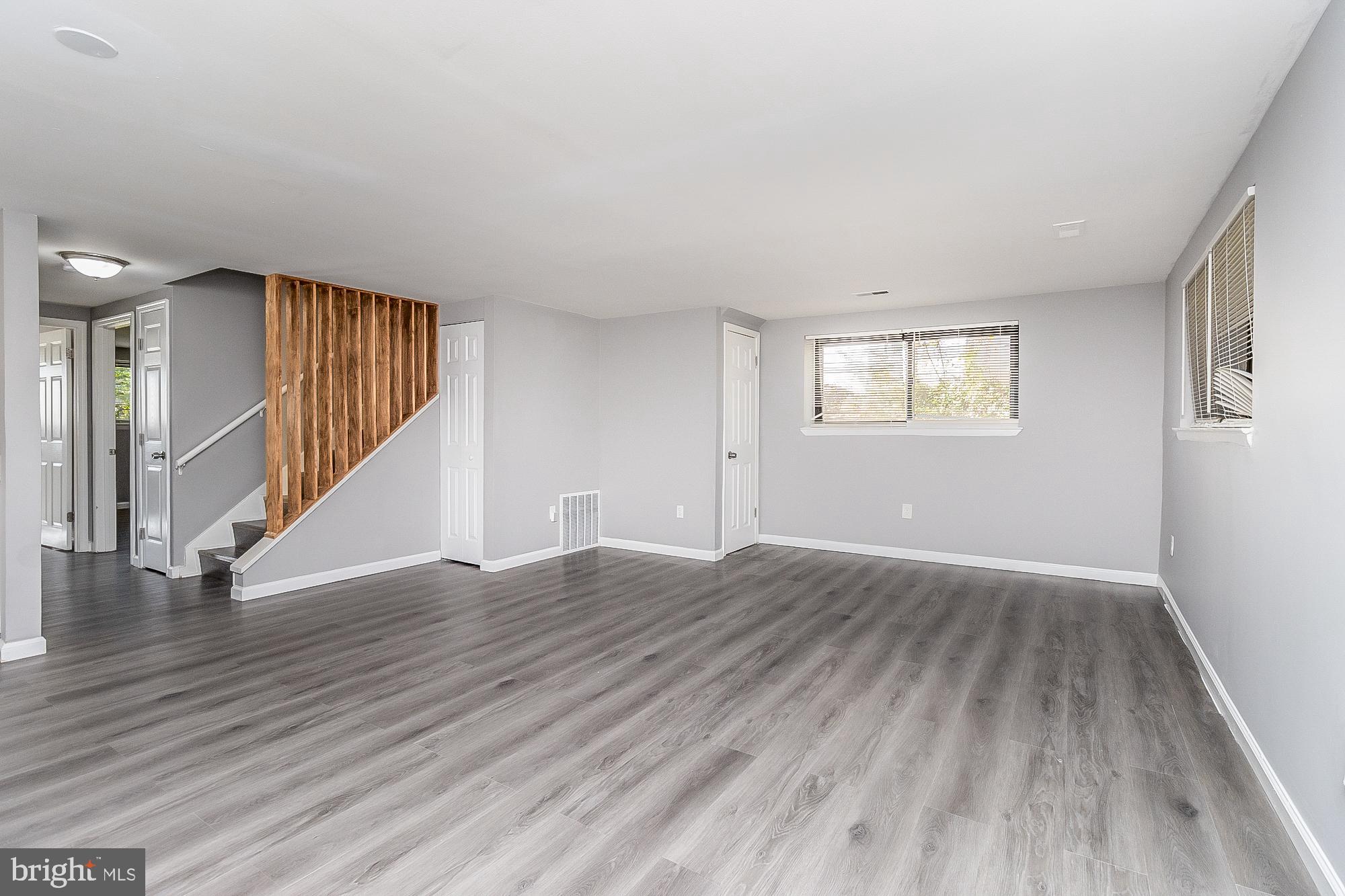 4006 Pinewood Avenue, Unit 1 Baltimore, MD 21206 - Photo 8 of 25 an empty room with wooden floor and windows