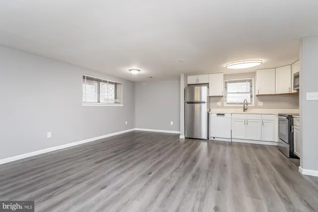 a view of a kitchen with wooden floor and electronic appliances