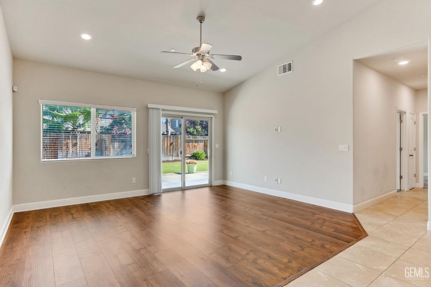 Undisclosed Address Bakersfield, CA 93311 - Photo 20 of 39 an empty room with wooden floor chandelier and windows