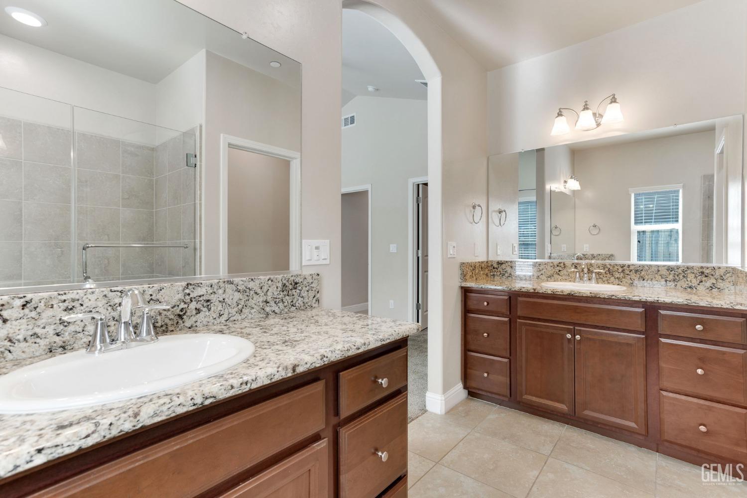 Undisclosed Address Bakersfield, CA 93311 - Photo 29 of 39 a bathroom with a granite countertop double vanity sink and a mirror