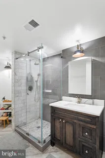 a bathroom with a shower sink and mirror