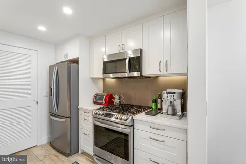 a kitchen with stainless steel appliances a stove microwave and refrigerator