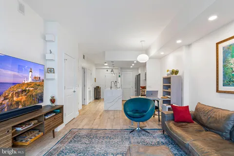a living room with furniture a flat screen tv and a large window