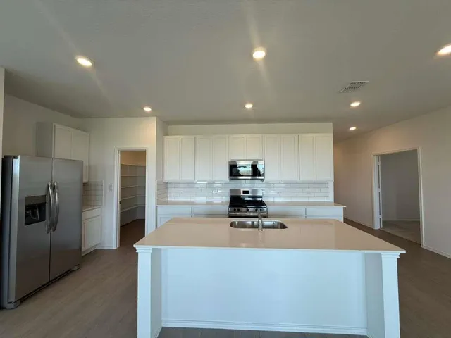 a view of a kitchen with a sink and a refrigerator