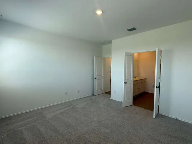 a view of a kitchen with kitchen island white cabinets and refrigerator