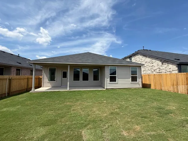 a view of a house with a yard and a large tree