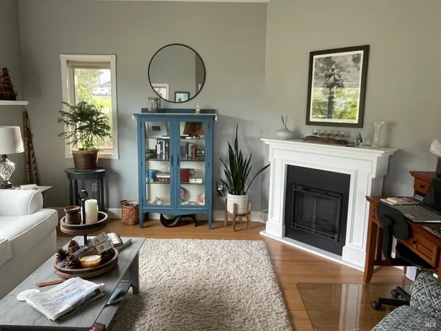 a living room with furniture a fireplace and a large mirror