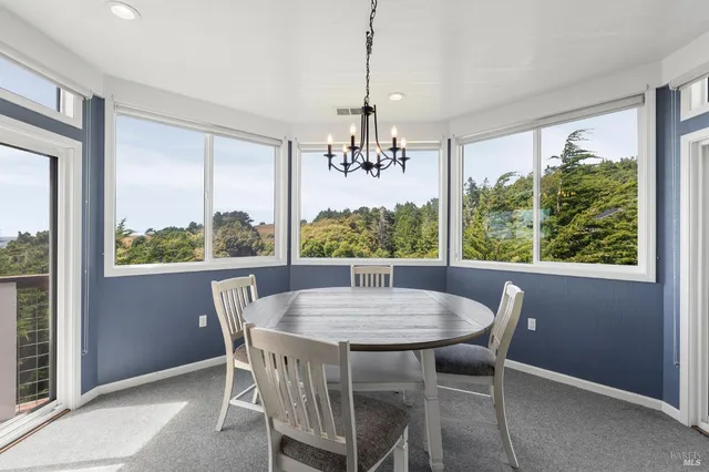 a view of a dining room with furniture a chandelier and wooden floor